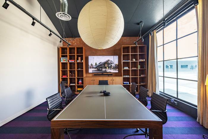 Mother Industries conference room after build-out, with custom lighting and built-in shelving